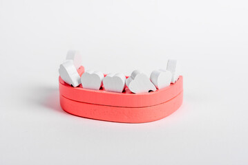 Wooden jaw model with loose crooked teeth. Primary milk tooth loss, replacement with permanent ones. Dental health, stomatology concept. High quality photo - obrazy, fototapety, plakaty