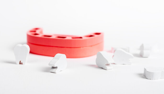 Toothless wooden jaw model with missing teeth. Primary tooth loss or extraction caused by dental problems, cavity, gum disease, injury concept. Oral hygiene, stomatology. High quality photo