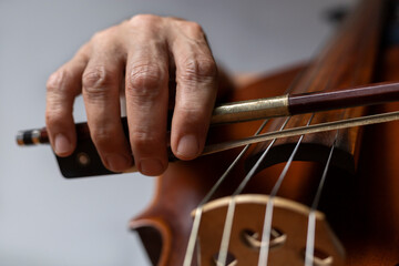Close-up of the hand holding the bow at the heel and placed correctly on the G string on the cello....