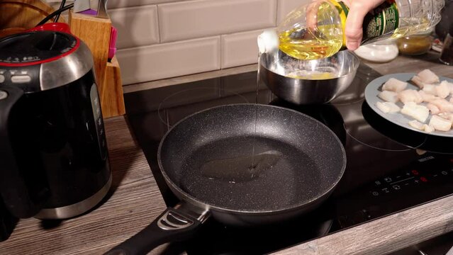 homemade fried fish in batter step by step. step 3 sunflower oil is poured onto a frying pan heated on the stove