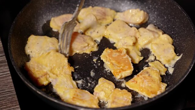 homemade fried fish in batter step by step. step 6 pieces of fish fried in oil in a heated frying pan are turned over with a fork