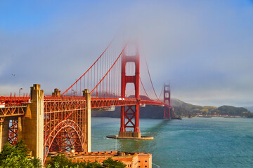 Fog covering top of Golden Gate Bridge in San Francisco with vibrant colors