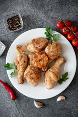 grilled chicken legs with spices on a stone background