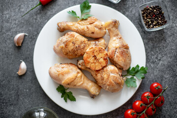 grilled chicken legs with spices on a stone background