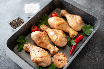 grilled chicken legs with spices on a stone background