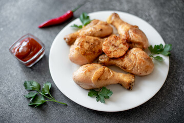 grilled chicken legs with spices on a stone background