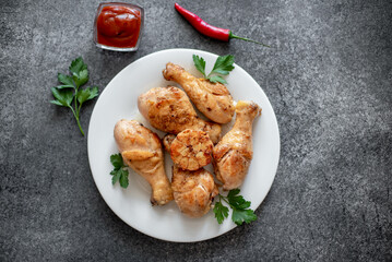 grilled chicken legs with spices on a stone background