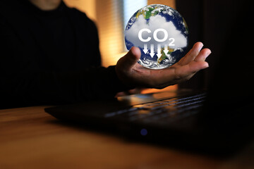 Hand holding globes and clouds is a way to reduce carbon dioxide emissions and other activities...