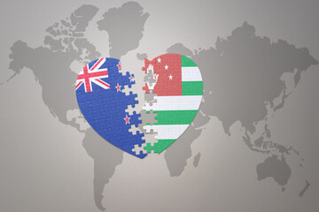 puzzle heart with the national flag of new zealand and abkhazia on a world map background. Concept.