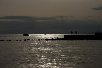 Fototapeta premium 江ノ島付近の釣り人のシルエットと海の夕景