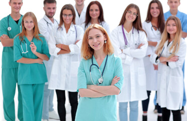 young female paramedic standing in front of her colleagues