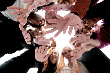 happy young people standing in a circle and showing thumbs up