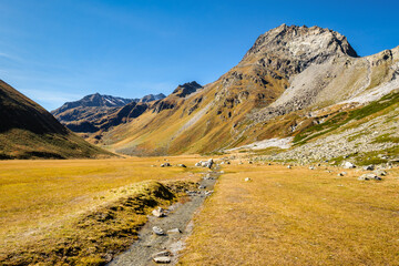Fototapeta na wymiar View at the Kaunergrat peaks Seekogel and Rostizkogel from the westside of Lake Rifflsee (largest lake in the Ötztal Alps), above the Pitztal Valley. Here the Rifflbach brook flows into the lake.