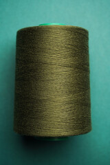 Green thread spool background, close-up