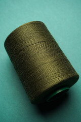 Green thread spool background, close-up