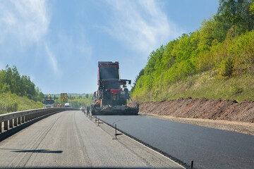 Laying asphalt on a suburban highway. Road works.