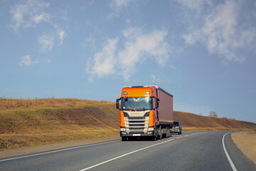 Fototapeta na wymiar The truck is moving along a suburban highway. Cargo transportation, logistics.