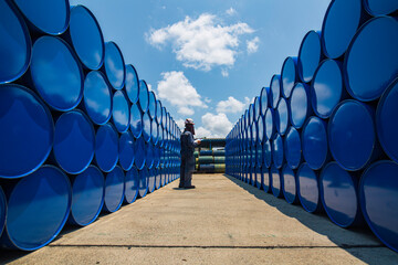 Male worker inspection drum oil stock barrels blue