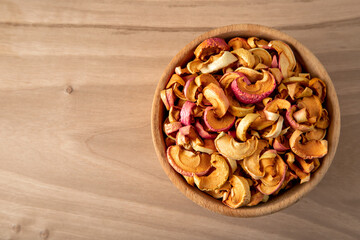 Bowl full of dried apples on a wooden background