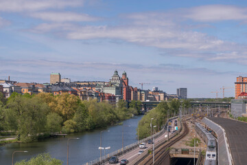 Fototapeta na wymiar Panorama over the districts Kungsholmen and Vasastan water fronts at the canal Karlbergskanalen. Offices, the street Norra Länken and a rail yard a sunny summer day in Stockholm