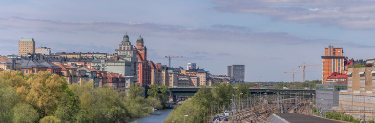 Panorama over the districts Kungsholmen and Vasastan water fronts at the canal Karlbergskanalen. Offices, the street Norra Länken and a rail yard a sunny summer day in Stockholm
