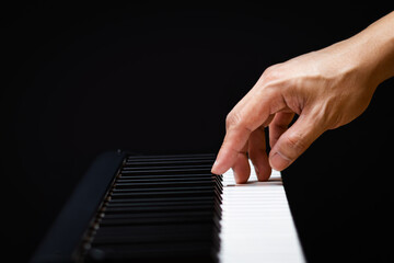 Fototapeta na wymiar male musician hand playing on piano keys. music background