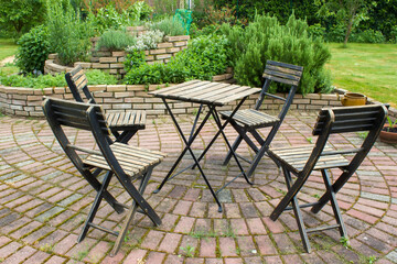 herb spiral in the garden and table with chairs