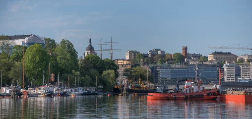 Foto op Canvas Panorama view over motor boats at piers in the islands Skeppsholmen and Blasieholmen, old military buildings and the district Södermalm in the background a sunny summer day in Stockholm © Hans Baath