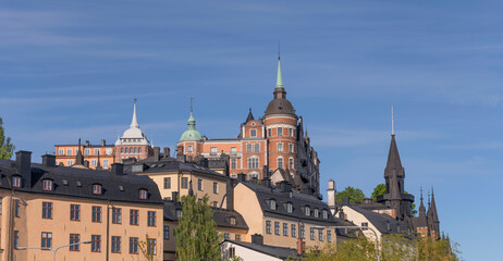 Fototapeta premium Old houses on a hill in the district Södermalm with tin roofs and dorms a sunny summer day in Stockholm