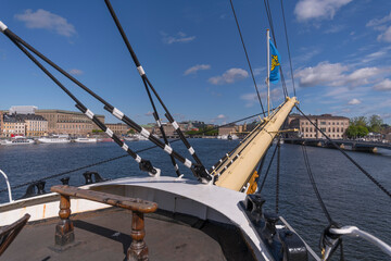 Fore deck view from the hostel three masts fully rigged new restored ship af Chapman in the bay Strömmen with the old town Gamla Stan and museums a sunny summer day in Stockholm