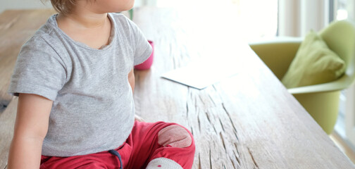 Anonymized view of a baby sitting on a table