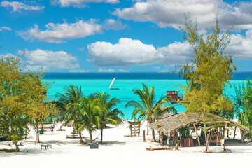 Belle plage de sable blanc paradisiaque vide et tranquille, chaises longues, palmiers, bar de cabane en bambou, eau turquoise - Paje, Zanzibar