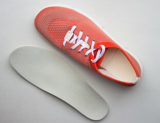 Orange sport shoes with orthopedic insoles on neutral background.. Top view.