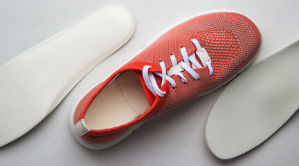 Orange sport shoes with orthopedic insoles on neutral background.. Top view.