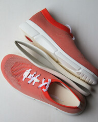 Orange sport shoes with orthopedic insoles on neutral background.. Top view.