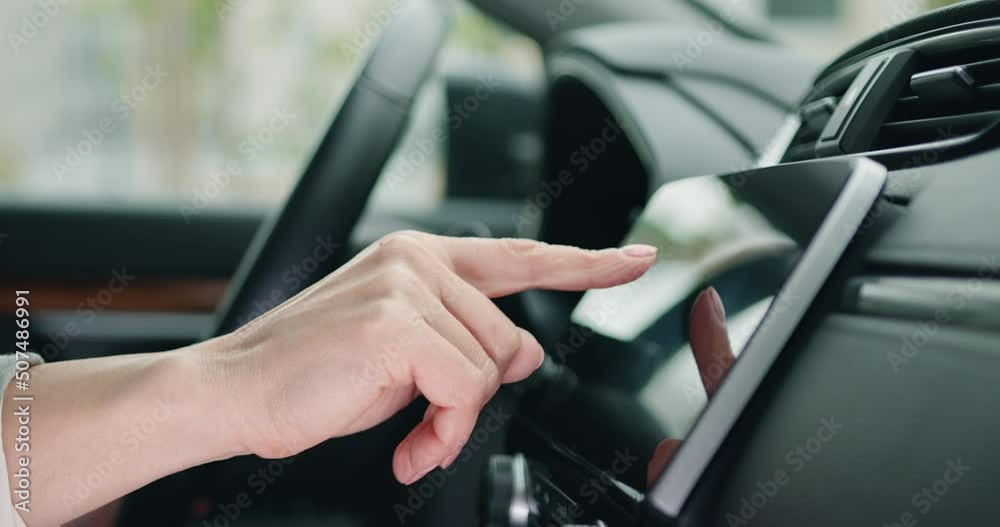Wall mural close up shot hand of woman using touch screen in car setting up the navigation gps application on t