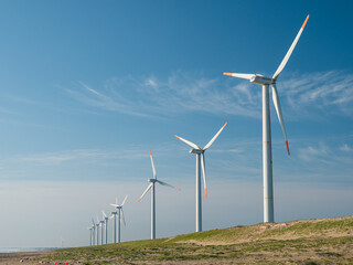 青空と海岸の風力発電の風車。茨城県神栖市須田浜海岸の波崎ウインドファーム。