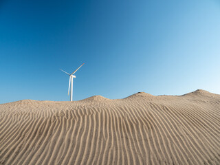青空と海岸の風力発電の風車。茨城県神栖市須田浜海岸の波崎ウインドファーム。