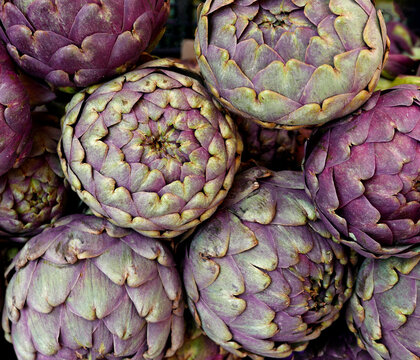 grande quantit&agrave; di carciofi in primo piano fotografati al mercato
