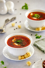 Beetroot soup with herbs and garlic on a light background.