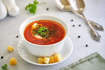 Beetroot soup with herbs and garlic on a light background.