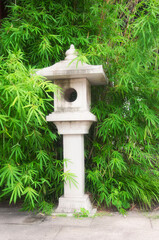 a chinese stone lantern nestled in bamboo trees