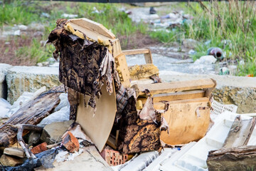 An old torn chair in a landfill