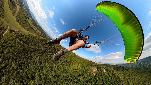 Man flying the paragliding at sunny day, adventure concept