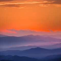 Fototapeta na wymiar mountain ridge silhouette in blue mist at the twilight, natural mountain travel background