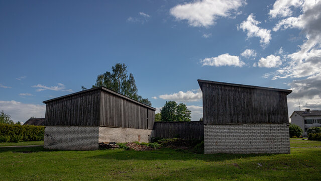 two barns made of white bricks and wood in Latvia village Garoza