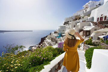 Amazing resort holiday vacation in Greece. Young beautiful girl walking in Oia village on Santorini...
