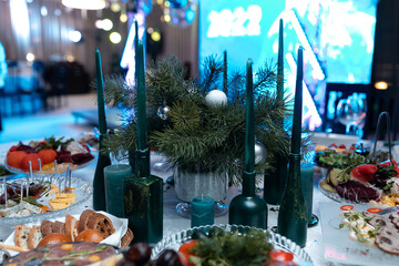 Candles on the holiday table. New Year's mood. Fir branches