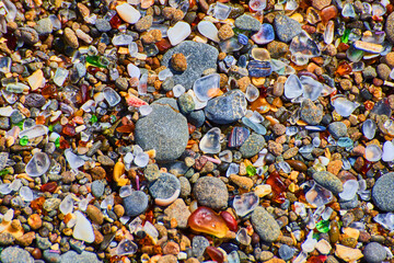Beach pebbles of smooth colorful rocks covering coast