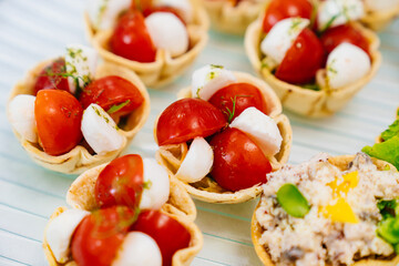 cherry tomatoes and mozzarella cheese in dough baskets.